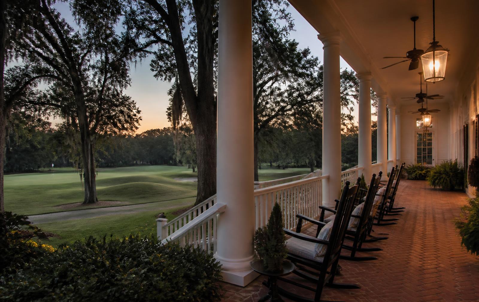 A columned club veranda overlooking the fairways at dusk near Quail Hollow